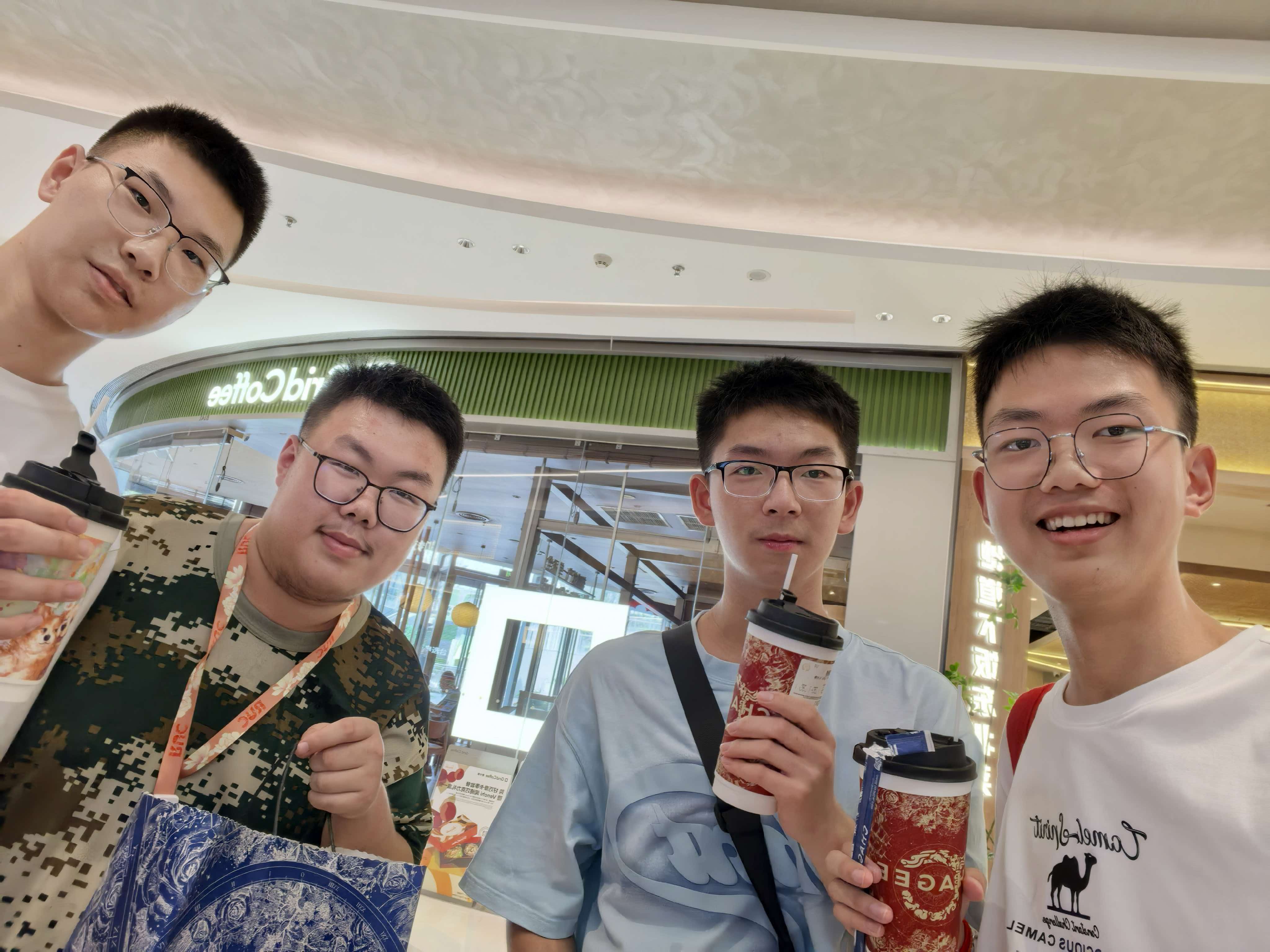 四位同学拿着奶茶合影